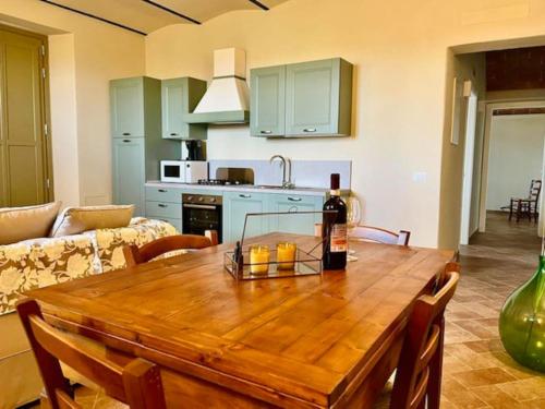 a kitchen with a wooden table with a bottle of wine at Sangi Chianti Vacations in Poggibonsi