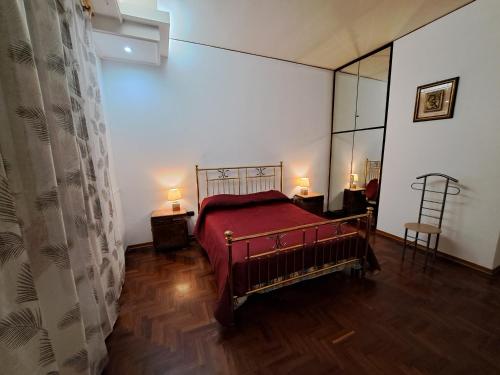 1 dormitorio con 1 cama con manta roja y espejo en marmar, en Marsala