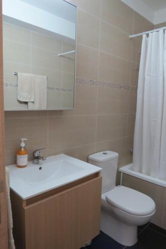 a bathroom with a toilet and a sink and a mirror at Mythical Sands AM10 in Paralimni