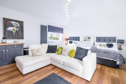 a living room with a white couch and a bed at Willow House Bed & Breakfast and Orchard Studios Self Catering in Limavady