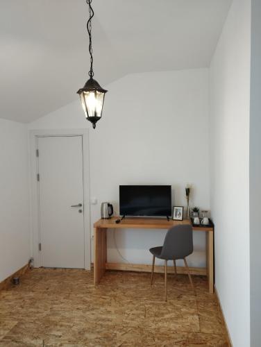a room with a desk with a chair and a television at MiddleHouse in Braşov