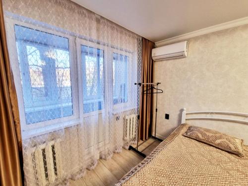 1 dormitorio con cama y ventana en Люкс в центре, en Uralsk