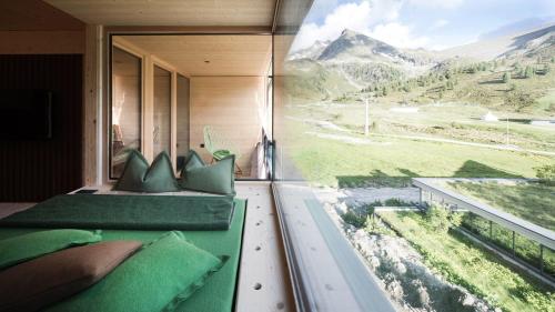 a room with two beds and a large window at Hotel Jagdschloss Resort in Kühtai