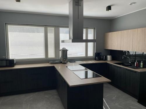 a kitchen with a counter top and some windows at Kassikäpa villa in Haapsalu