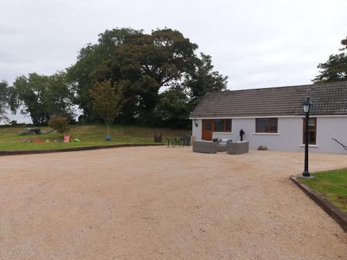 a house with a gravel driveway in front of it at St Patrick's Cottage 