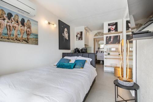 une chambre avec un grand lit blanc avec des oreillers bleus dans l'établissement CAP AGDE NATURISTE STUDIO PORT NATURE 3, au Cap d'Agde