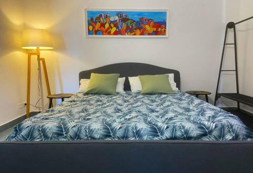1 cama en un dormitorio con una pintura en la pared en Gelsomino Sea View Suite & Spa en San Vito lo Capo
