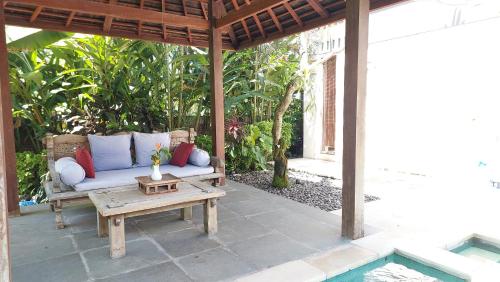 a porch with a couch and a table on a patio at Villa Rumah Isah in Candidasa