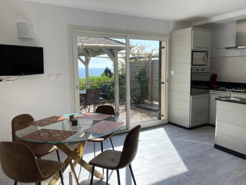 une cuisine et une salle à manger avec une table et des chaises en verre dans l'établissement Chez Jean Claude la villa des amis, à Olmeto