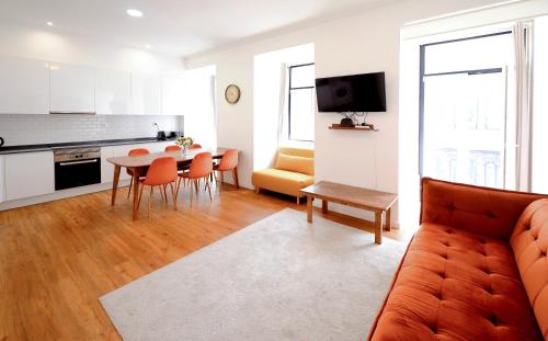 a living room with a couch and a table with chairs at Lisboa Intendente 3Bedroom Apartment with Balcony in Lisbon