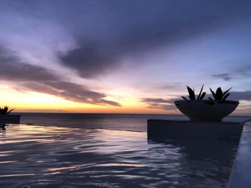 a pool with a view of the ocean at sunset at Bellavista Suites in Monopoli