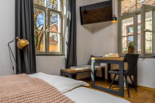 um quarto com uma secretária e uma cama e uma secretária em Gentry11 Rooms&More em Maribor