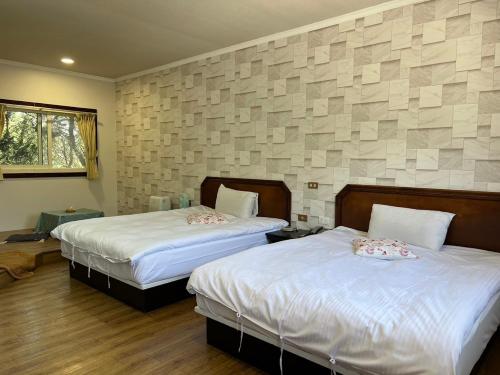 a bedroom with two beds and a wall with blocks at Bokelai B&B in Renai