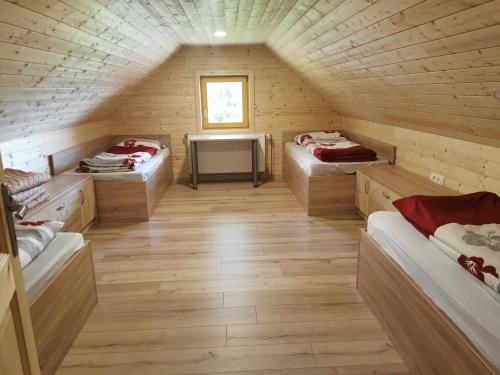 Habitación con 3 camas en una cabaña de madera en APARTMA BREST, en Gornji Grad