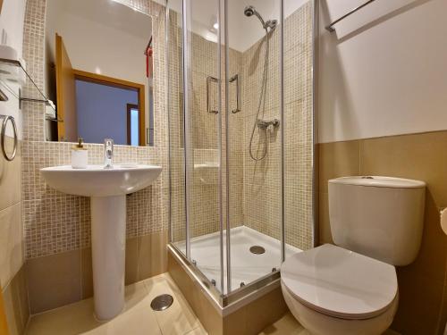 a bathroom with a shower and a toilet and a sink at Apartamento Royal Garden T2 by YHA in Conceição