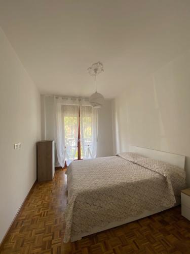 biała sypialnia z łóżkiem i oknem w obiekcie Casa grigio perla w mieście Vallecrosia