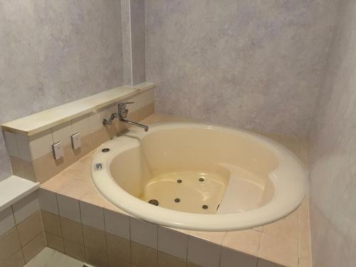 a bath tub in a bathroom with a sink at エリア５１ in Kishimoto