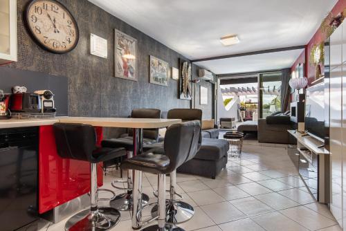 - un salon avec une table et une horloge murale dans l'établissement appartement village naturiste port ambonne, au Cap d'Agde