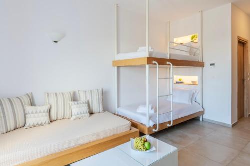 a living room with a couch and a bunk bed at Mykonaki Hotel in Ano Mera