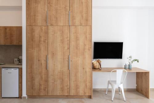 a room with a wooden partition with a desk and a tv at Mykonaki Hotel in Ano Mera
