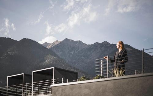 a woman standing on top of a building looking at the mountains at SomVita Suites in Tirolo
