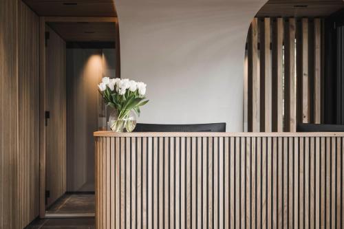 a vase of white flowers sitting on top of a counter at SomVita Suites in Tirolo