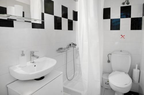Baño blanco con aseo y lavamanos en Thea Studios, en Kassiopi