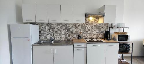 una cucina con armadietti bianchi e frigorifero bianco di Bel appartement centre ville. a Blaye