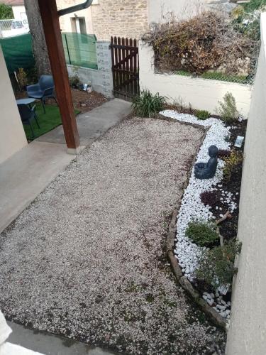 a backyard with a gravel yard with a black bird statue at Gîte des Pleiades in Villemoirieu