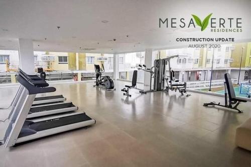 a gym with treadmills and machines in a building at Studio unit at Mesaverte Residence in Cagayan de Oro