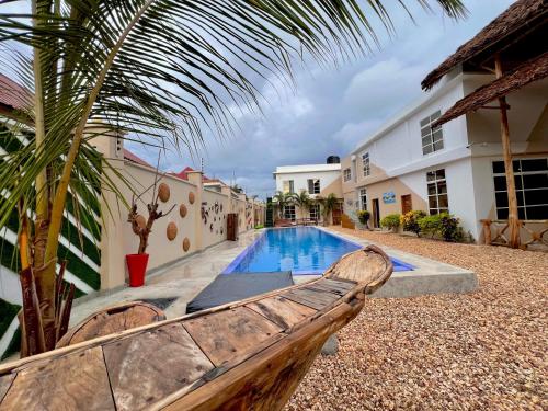 a wooden bench sitting next to a swimming pool at VICK Boutique Hotel with NEW power backup in Nungwi