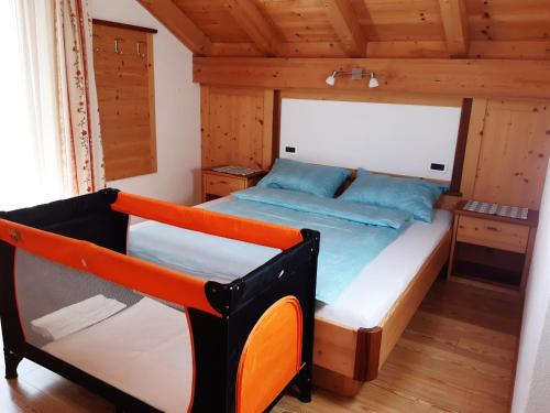 een slaapkamer met een bed in een houten hut bij Raisc - La tua casa in Val Badia in La Villa
