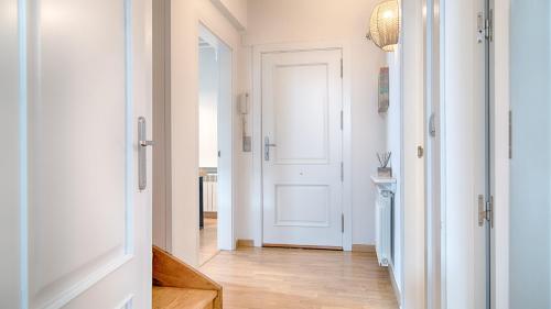 pasillo con puerta blanca y suelo de madera en Saplan Real Estate PIJAUERT, en Les