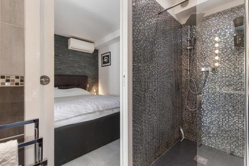 een badkamer met een douche en een bed in een kamer bij VILLA PORT NATURE village naturiste in Cap d'Agde