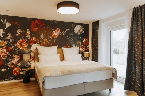 a bedroom with a floral wall mural and a bed at Blumen(t)raum - Ferienwohnung in Karlsruhe in Karlsruhe