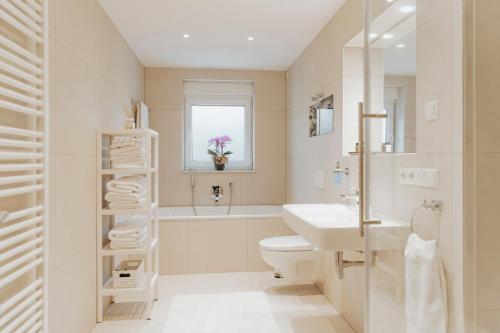 a white bathroom with a sink and a toilet at Blumen(t)raum - Ferienwohnung in Karlsruhe in Karlsruhe
