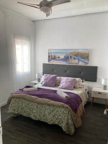 a bedroom with a large bed with purple pillows at Spacious vintage 18 in Vinarós