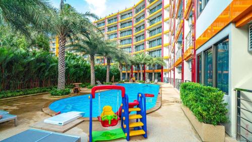 a pool with a slide in front of a building at Modern MBC condo near the beach in Ban Bo Sai Klang