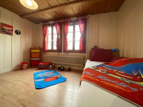 a bedroom with a bed and a window and a bedroom with a childs room at Wohnen mit Blick auf Eiger - ehemaliges Bauernhaus - 2 Schlafzimmer in Schwarzenburg
