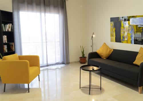a living room with a couch and a chair at PAPALi 289 in Catania
