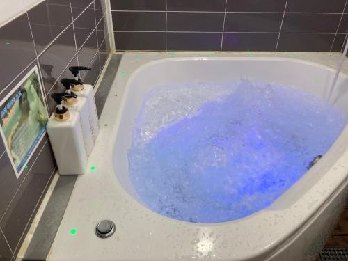 eine Badewanne mit blauem Wasser im Bad in der Unterkunft Cozy Motel in Yangpyeong