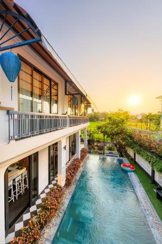 an exterior view of a building with a swimming pool at Lavini Hoian Boutique Villa in Hoi An