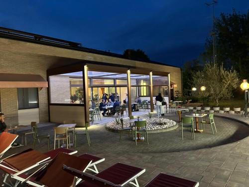 un patio con sillas y mesas en un edificio en Hotel Tre Ville, en Parma