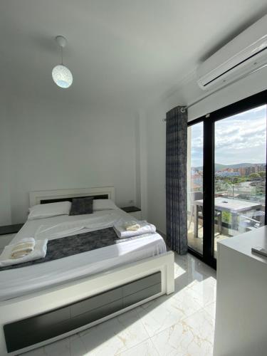 um quarto com uma cama e uma grande janela em Villa Mucodemi 1 em Ksamil