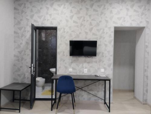 Habitación con escritorio y TV en la pared. en HAZINIY HOTEL, en Tashkent