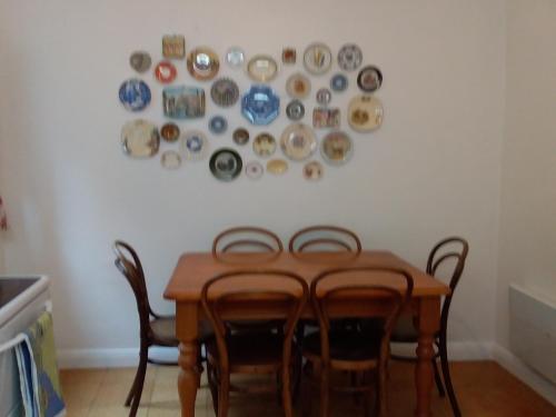 荷伯特的住宿－Josie's Cottage，餐桌、椅子和盘子挂在墙上