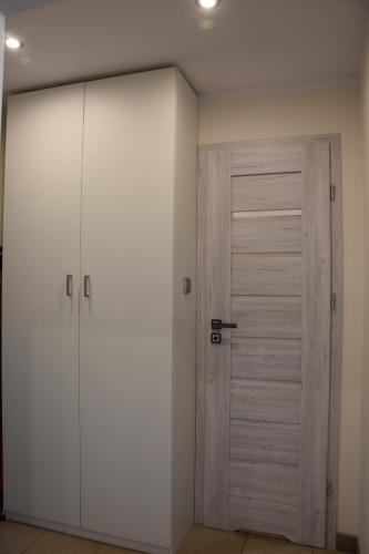 biała szafa z drzwiami w pokoju w obiekcie Apartament Centrum - Aleja Świętego Jana Pawła II w Kołobrzegu