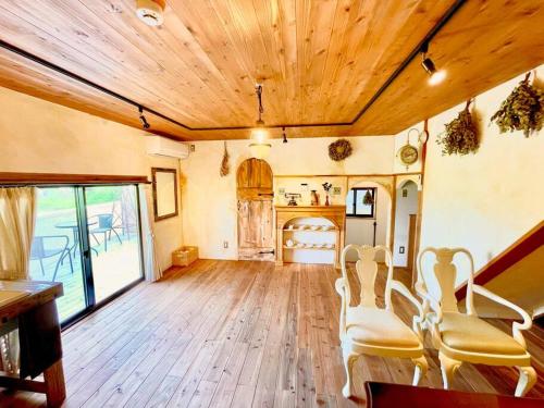 a living room with wooden floors and a wooden ceiling at 一棟貸し　魔女の休日CLUB in Nagano