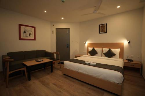 a hotel room with a bed and a couch at GRAND GANPAT in Vellore