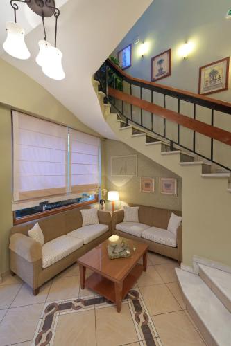 a living room with couches and a staircase at Anesis in Kastoria